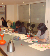 A woman siting at a desk in a classroom.